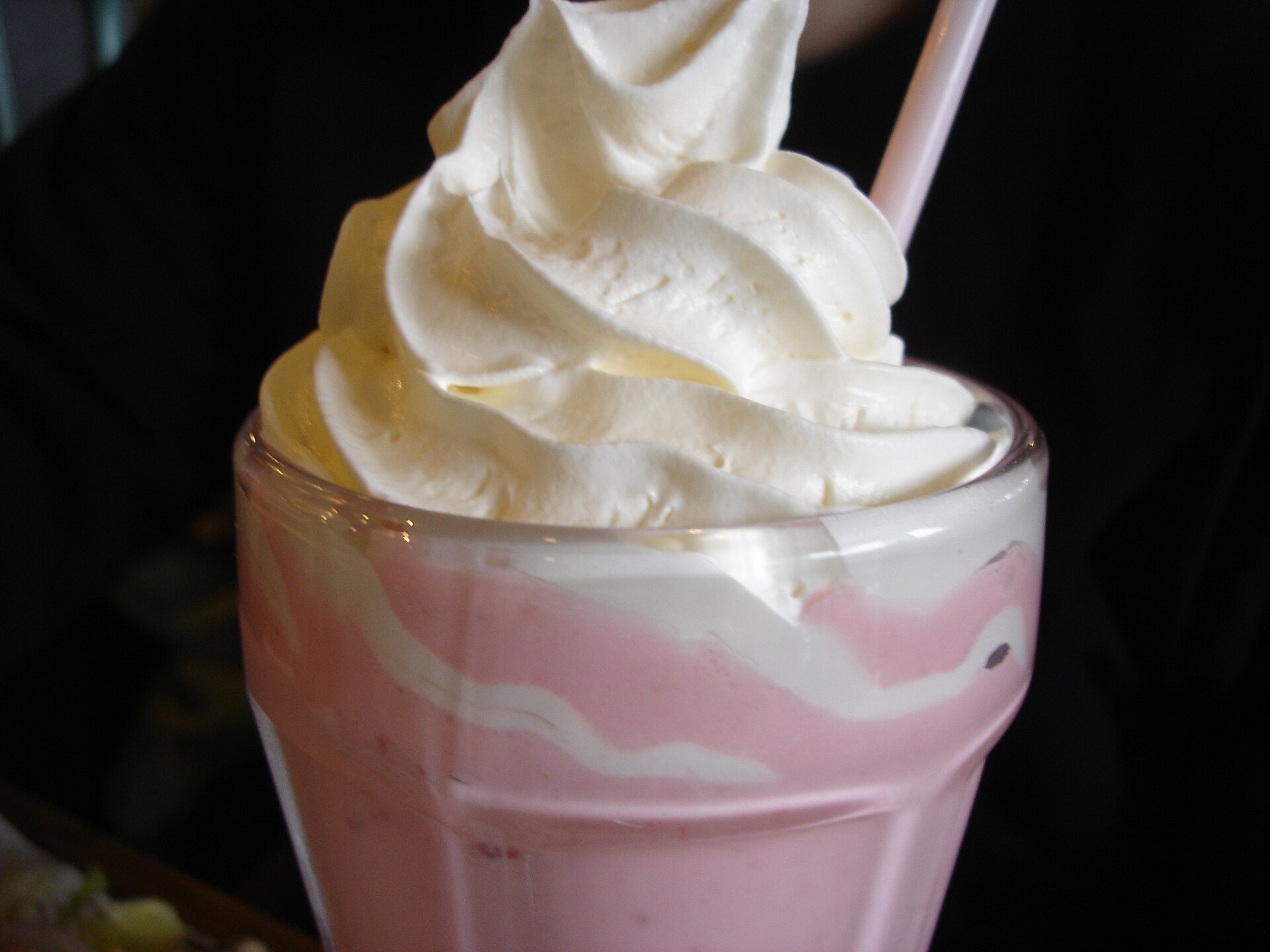 ホイップクリームをのせたピンクのいちごミルクシェイク。